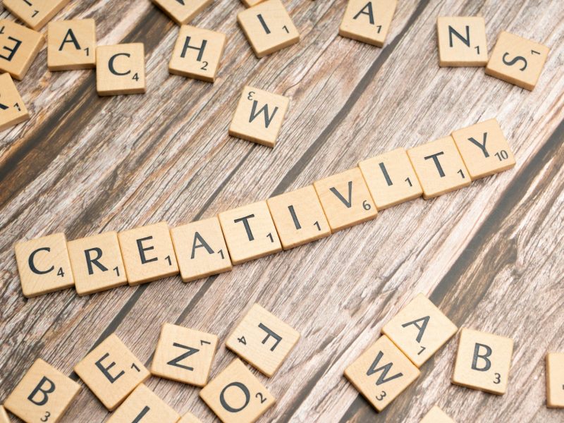 scrabble tiles spelling creativity on a wooden surface